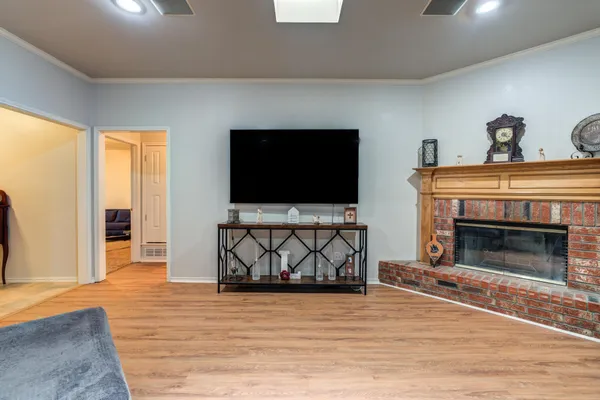 a kitchen with stainless steel appliances granite countertop a stove top oven a sink dishwasher a dining table and chairs with wooden floor