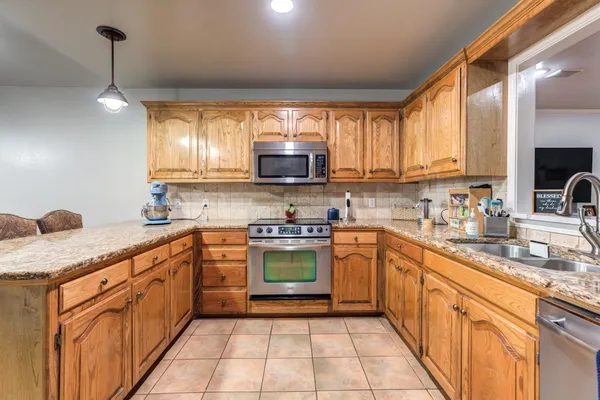 a bedroom with a large bed a chandelier and a window