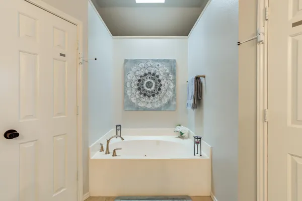 a spacious bedroom with a bed and a chandelier