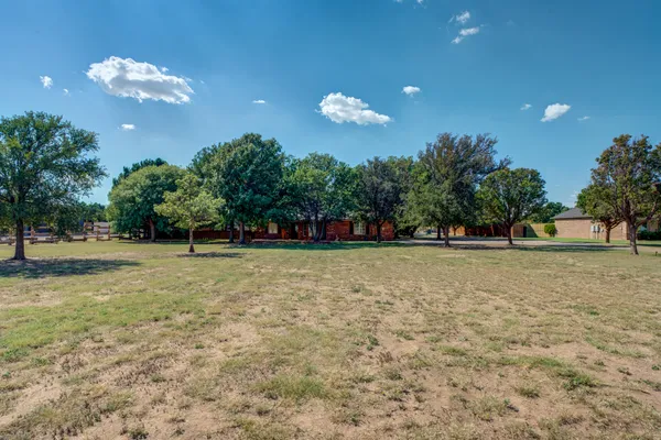 a view of a house with backyard and a tree