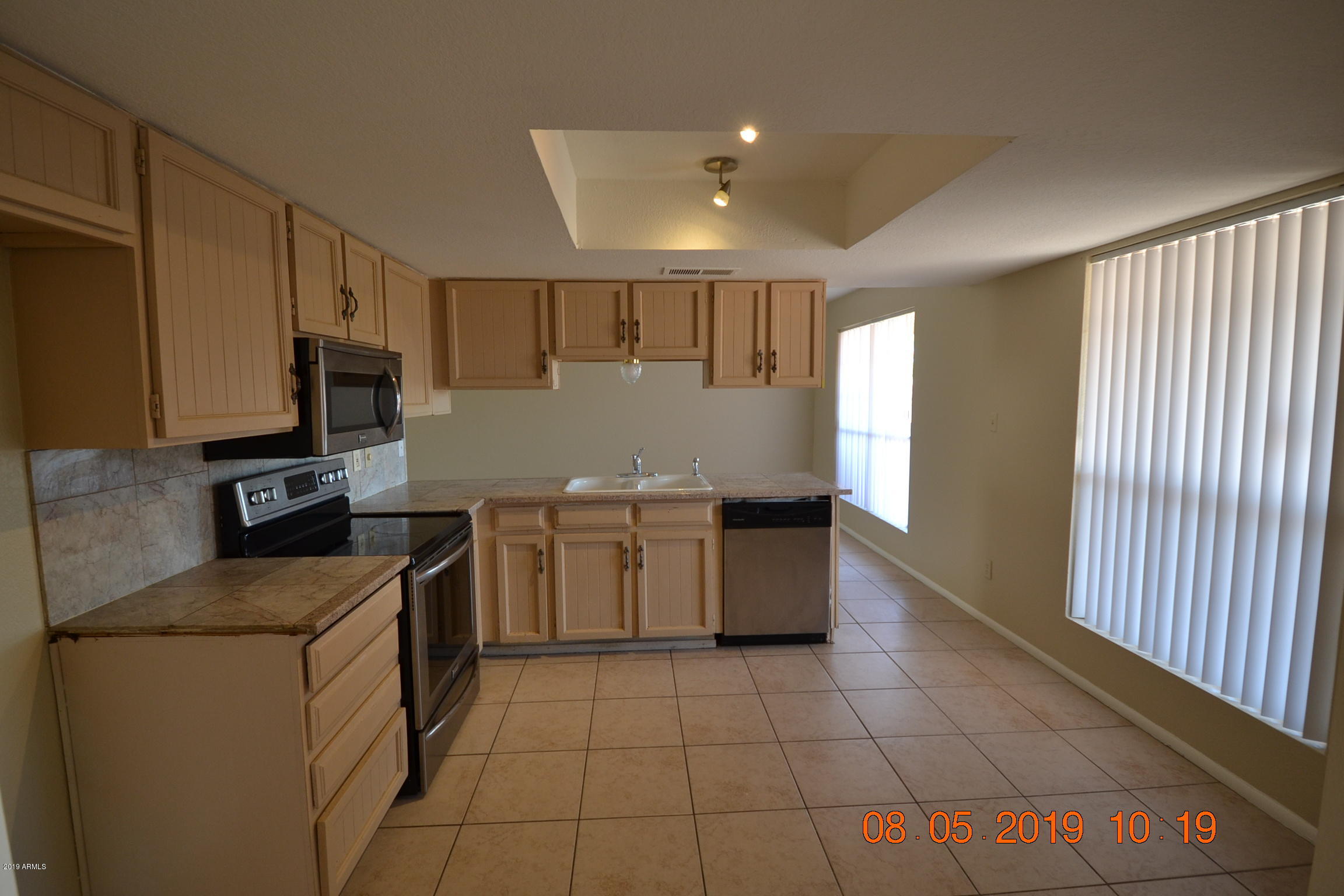 1431 West Behrend Drive Phoenix, AZ 85027 - Photo 2 of 15 a kitchen with a sink a stove top oven a counter space and cabinets