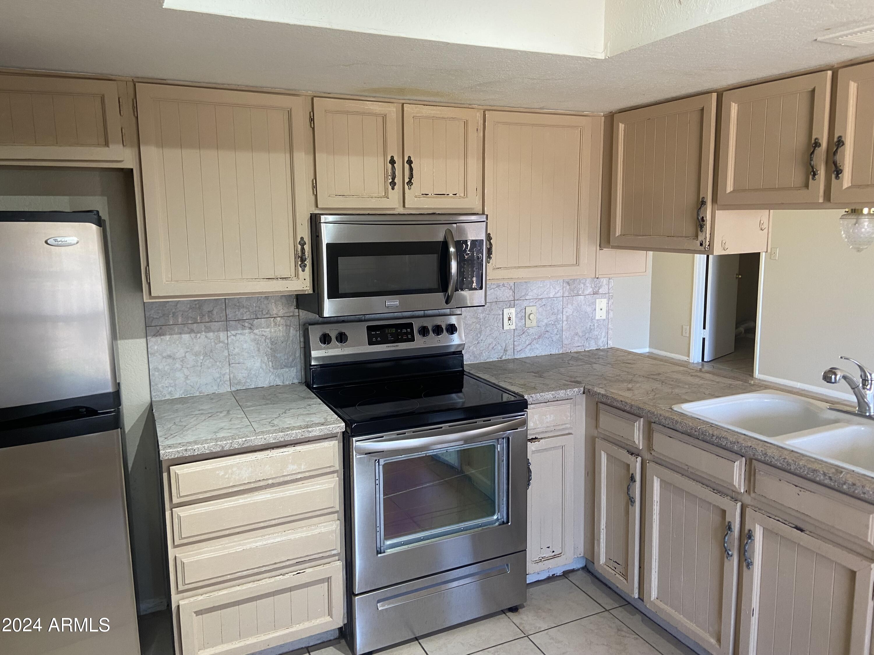 1431 West Behrend Drive Phoenix, AZ 85027 - Photo 3 of 15 a kitchen with granite countertop a sink stove and microwave