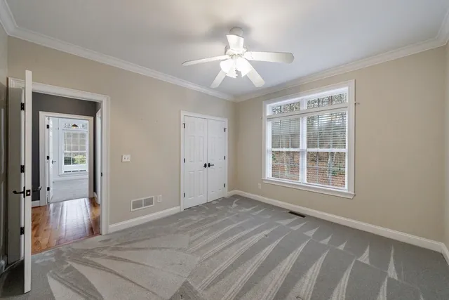 a view of a livingroom with a chandelier fan and windows