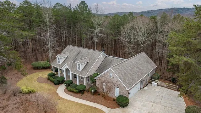 an aerial view of a house with yard and mountain view in back