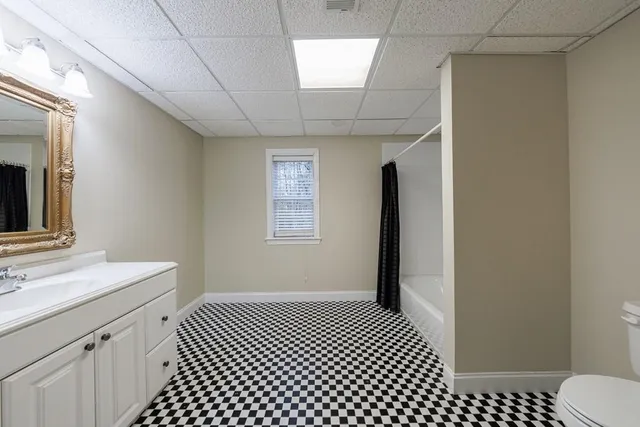 a bathroom with a sink a toilet a mirror and shower