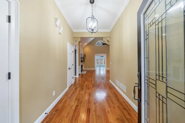 a view of a hallway with wooden floor and staircase