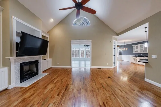 a view of empty room with wooden floor and fireplace