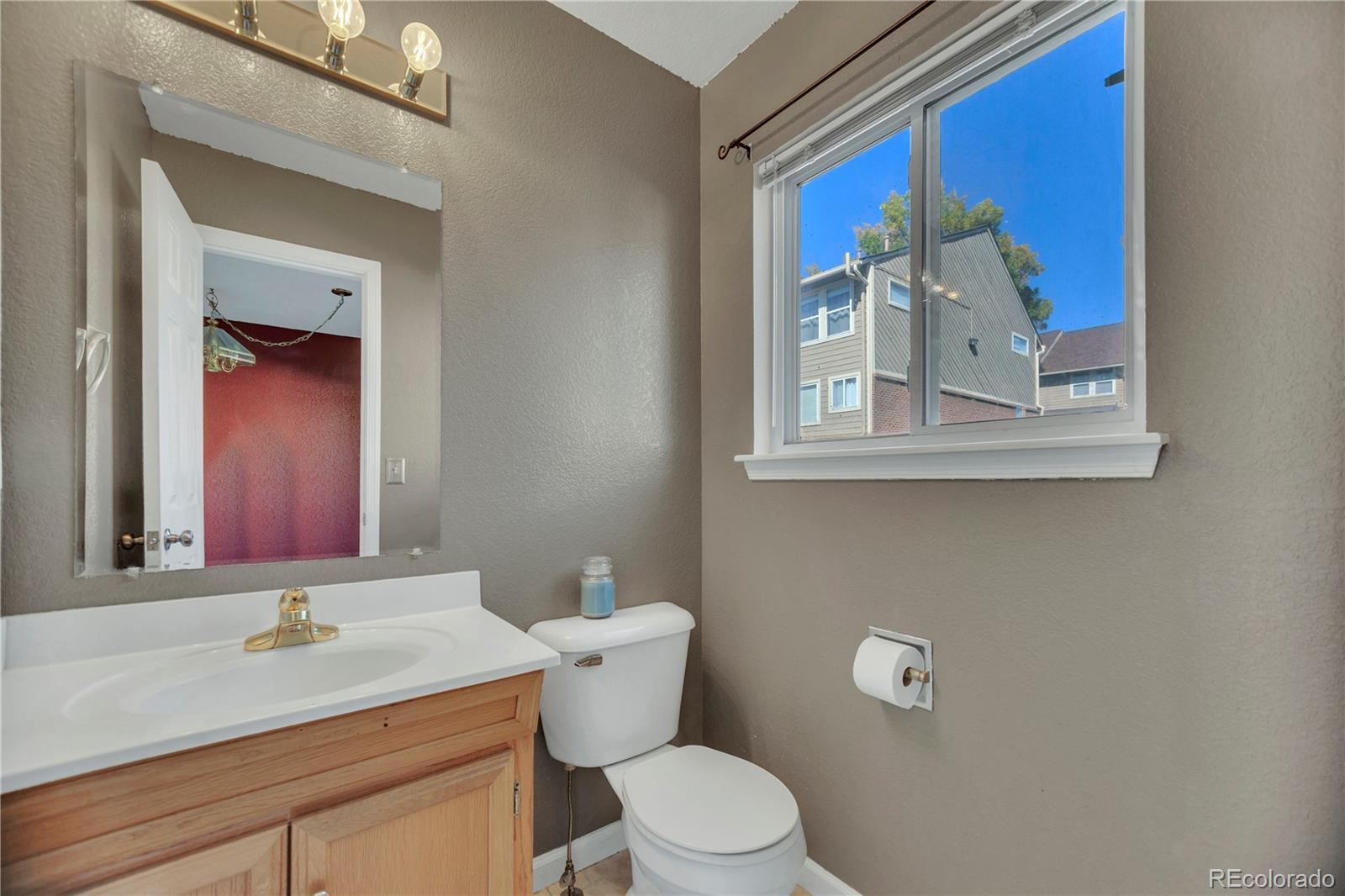 3300 West Florida Avenue, Unit 80 Denver, CO 80219 - Photo 18 of 24 a bathroom with a toilet a sink and mirror
