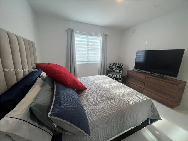 a bedroom with a bed and flat screen tv