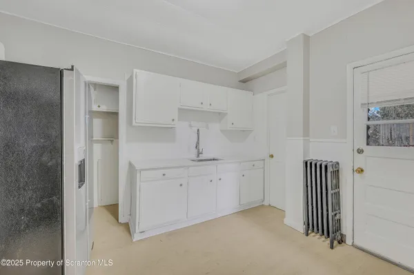 a kitchen with white cabinets and sink