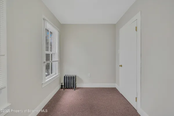 a view of a hallway with wooden floor and windows