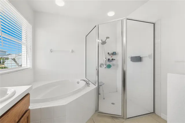 a bathroom with a bathtub a sink a vanity and a shower