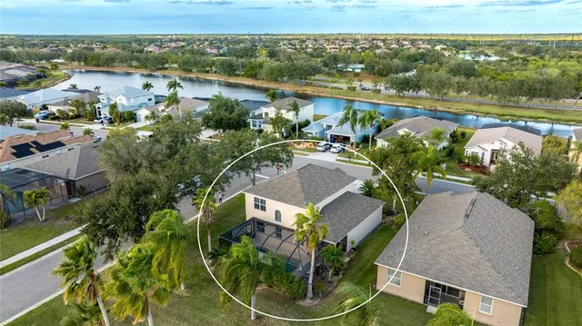 an aerial view of residential houses with outdoor space and lake view