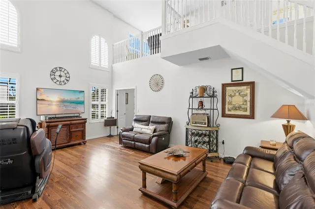 a living room with furniture a clock on wall and a table