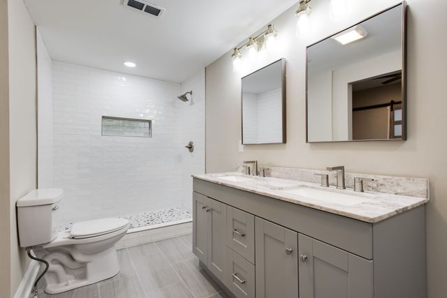 a bathroom with a toilet a sink a mirror and a bathtub