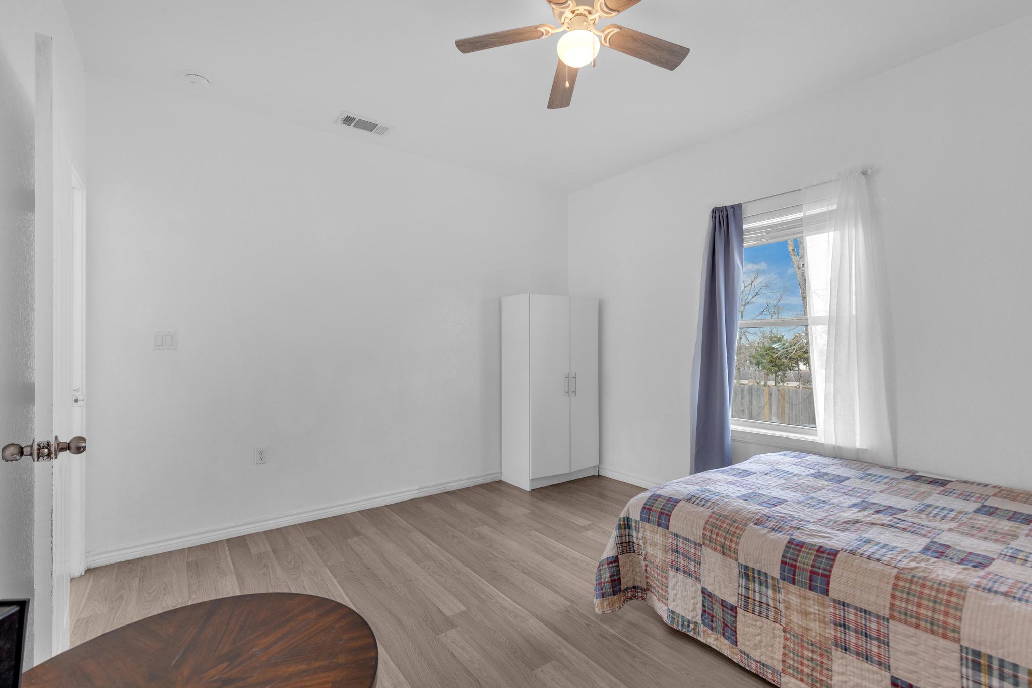 114 Crepe Myrtle Parkway Elgin, TX 78621 - Photo 16 of 40 a bedroom with a bed and a chandelier