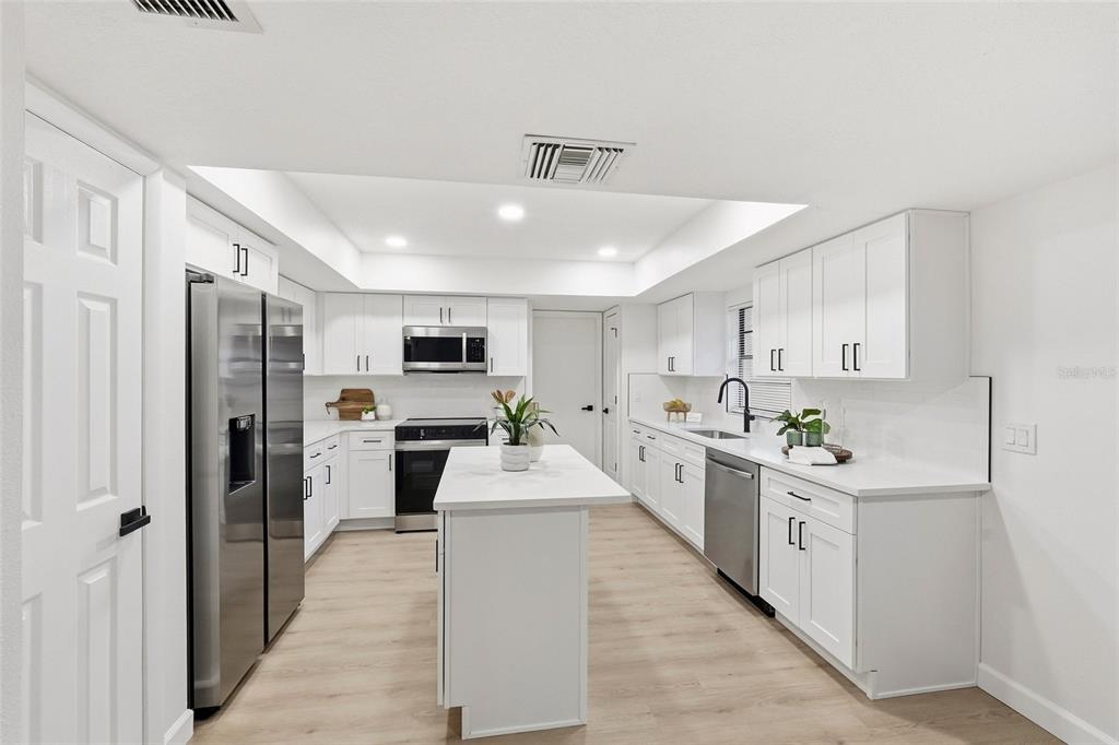 404 Bryan Oak Avenue Brandon, FL 33511 - Photo 11 of 43 a kitchen with white cabinets and stainless steel appliances