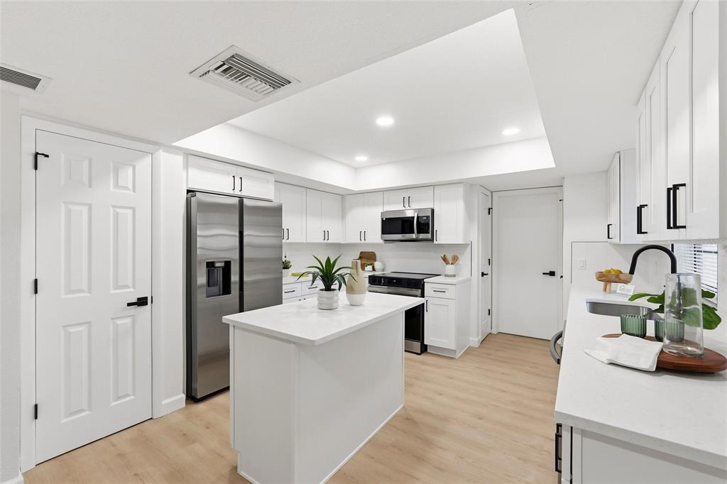 404 Bryan Oak Avenue Brandon, FL 33511 - Photo 12 of 43 a kitchen with stainless steel appliances a refrigerator sink and white cabinets