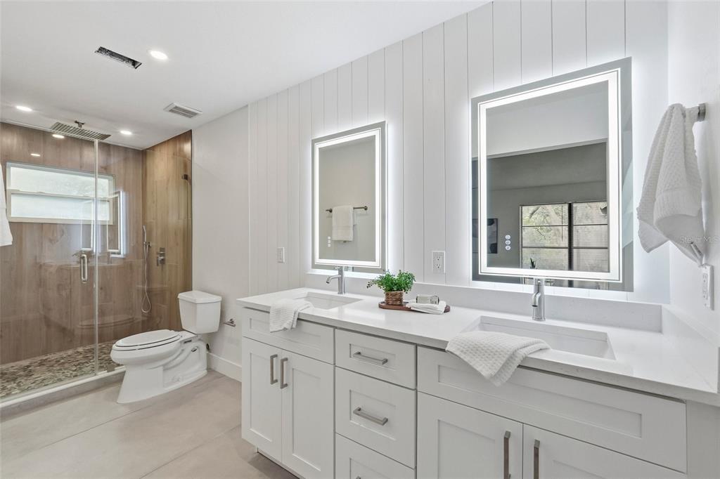 404 Bryan Oak Avenue Brandon, FL 33511 - Photo 19 of 43 a spacious bathroom with a double vanity sink toilet mirror and shower