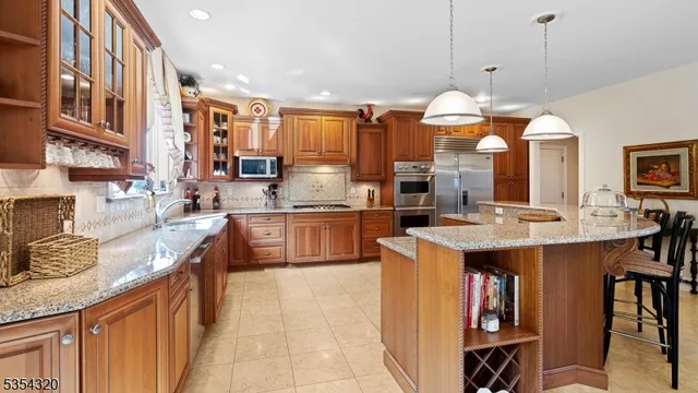 a kitchen with stainless steel appliances granite countertop a sink a stove and a wooden floors
