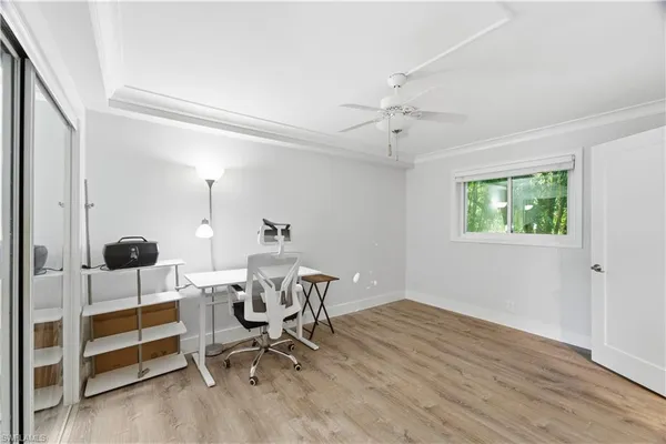 a view of a workspace with wooden floor and a window