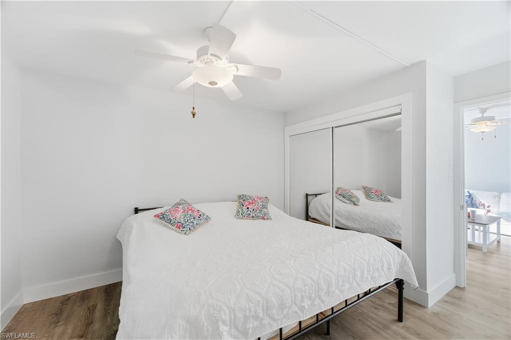 975 9th Avenue South, Unit 11 Naples, FL 34102 - Photo 14 of 19 a bedroom with a bed and a chandelier