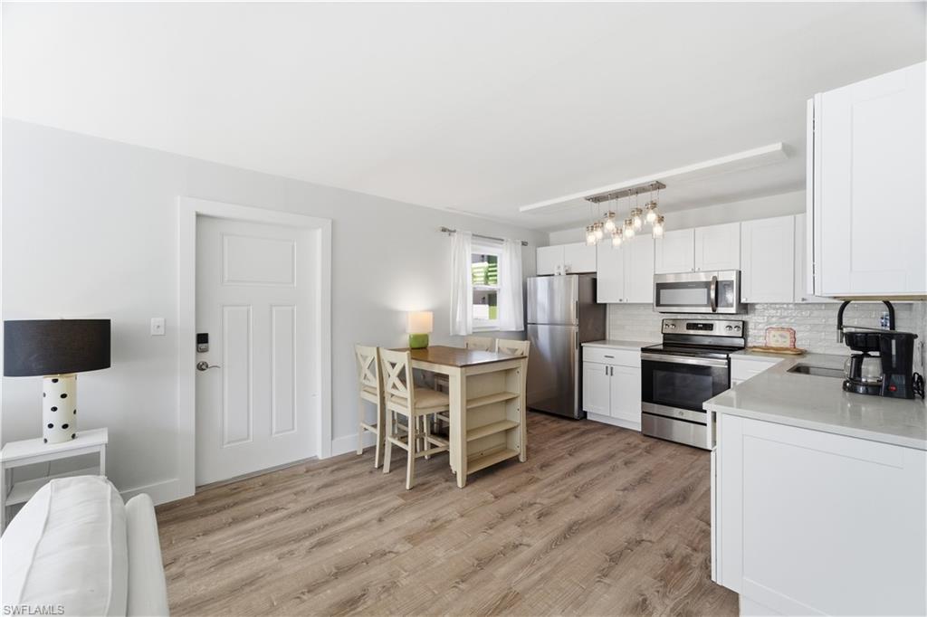 975 9th Avenue South, Unit 11 Naples, FL 34102 - Photo 5 of 19 a kitchen with a sink a counter top space stainless steel appliances and a window