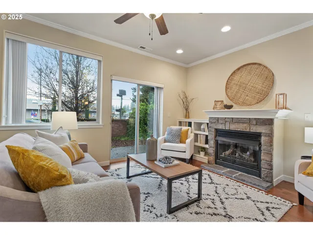 a living room with furniture a fireplace and floor to ceiling windows