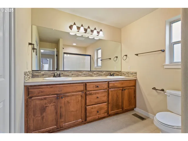 a spacious bathroom with a granite countertop sink a toilet and a mirror