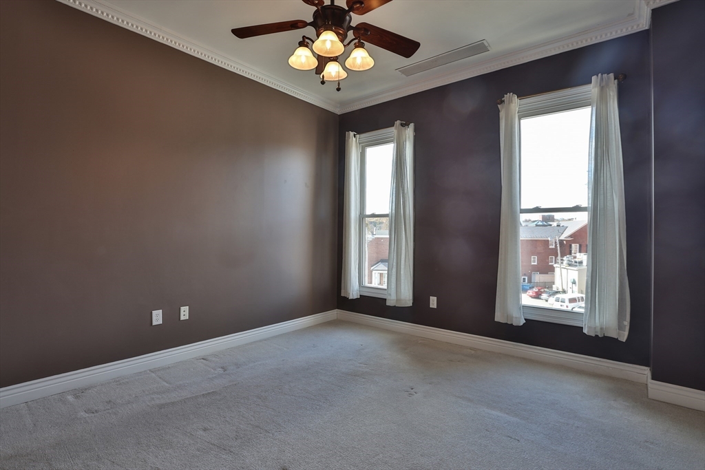 21 South Street, Unit 31 Westborough, MA 01581 - Photo 11 of 19 an empty room with windows and chandelier fan