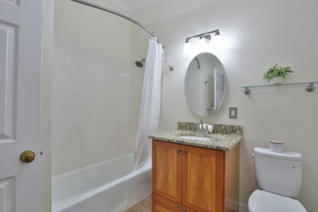 a bathroom with a granite countertop sink mirror vanity and toilet