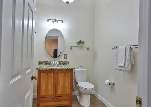 a bathroom with a toilet a sink and mirror