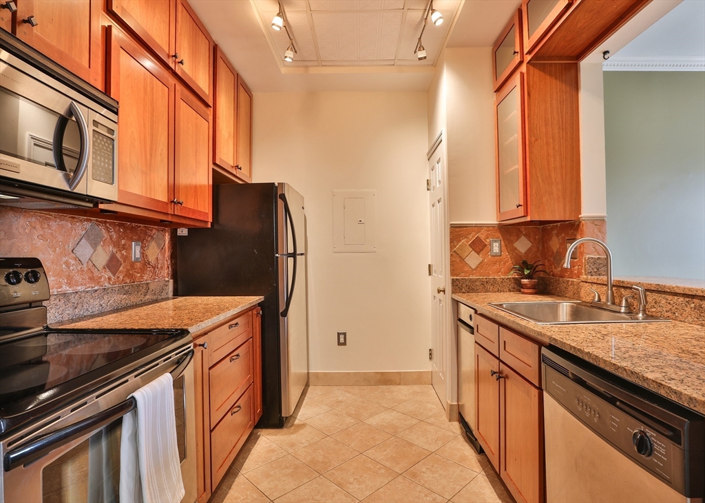 21 South Street, Unit 31 Westborough, MA 01581 - Photo 8 of 19 a utility room with granite countertop a sink and a stove top oven