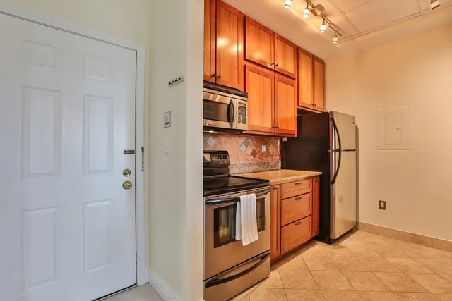 a kitchen with stainless steel appliances granite countertop a refrigerator and a stove top oven