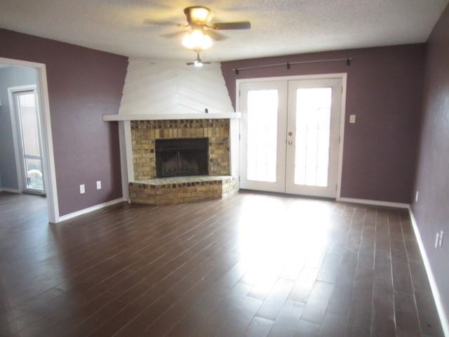4262 Madera Road Irving, TX 75038 - Photo 6 of 15 an empty room with wooden floor fireplace and windows