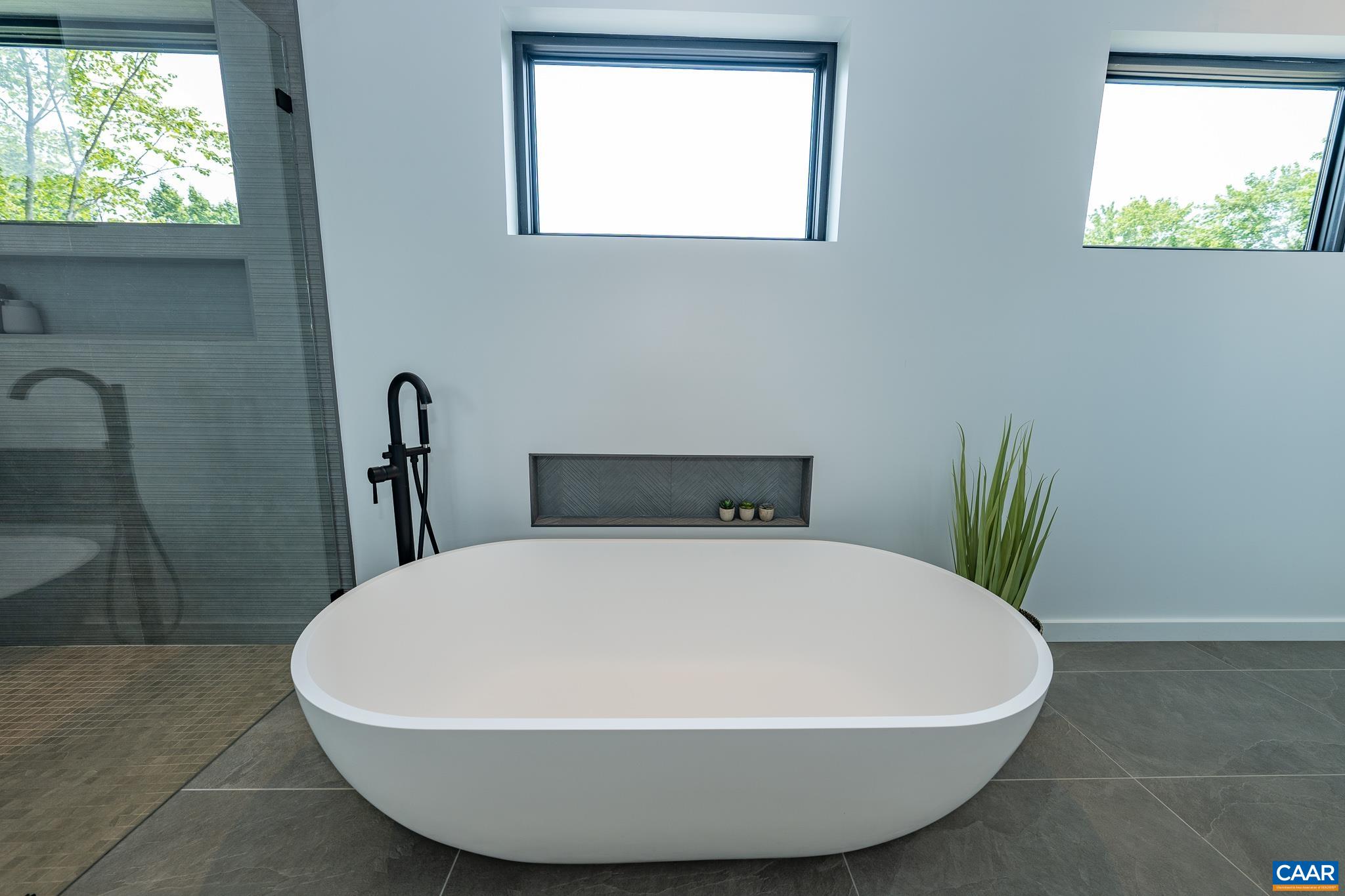 809 Gilliams Mountain Road Charlottesville, VA 22903 - Photo 38 of 68 a white tub sitting in a bathroom next to a window