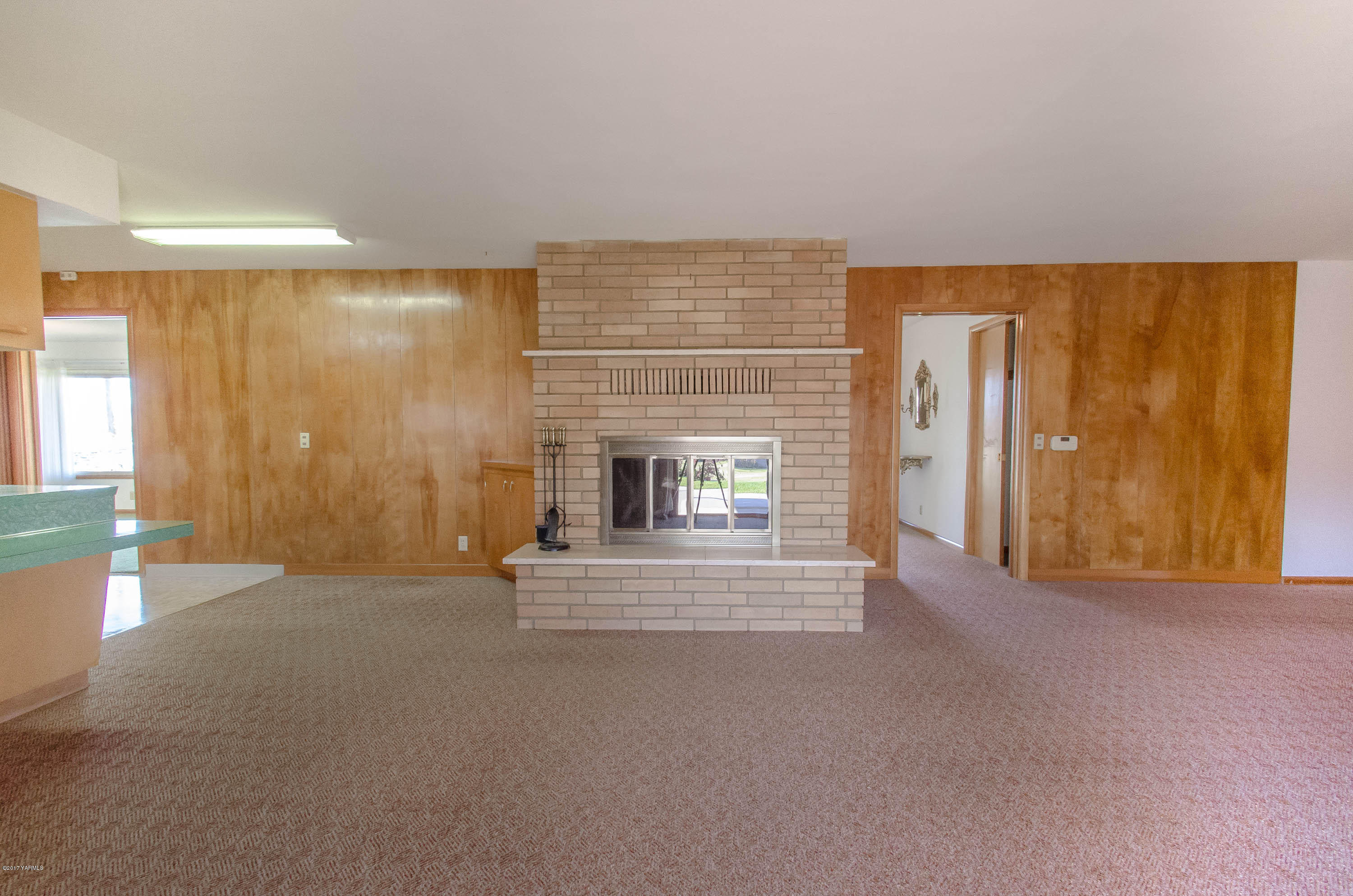 3591 Harrah Road Harrah, WA 98933 - Photo 6 of 20 an empty room with fireplace and windows