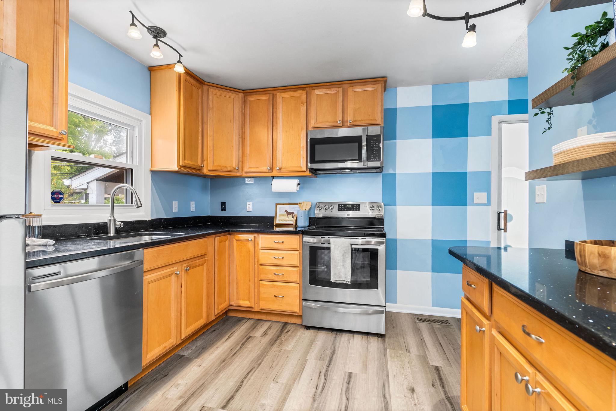 a kitchen with stainless steel appliances a stove a sink and a refrigerator