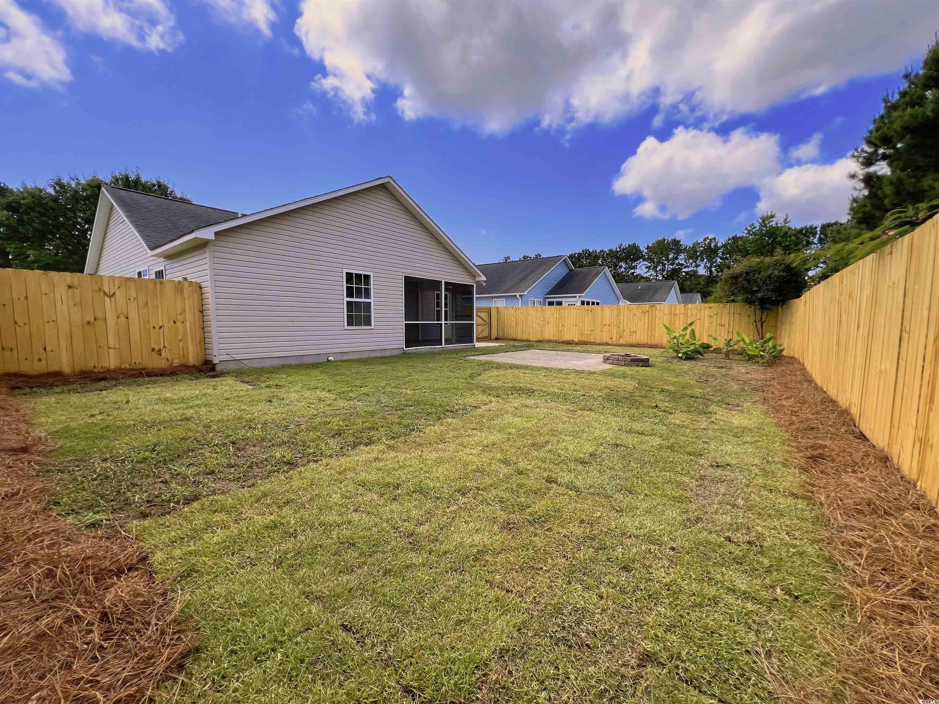 9888 Conifer Lane Murrells Inlet, SC 29576 - Photo 11 of 11 Fenced backyard with a sunroom and a patio