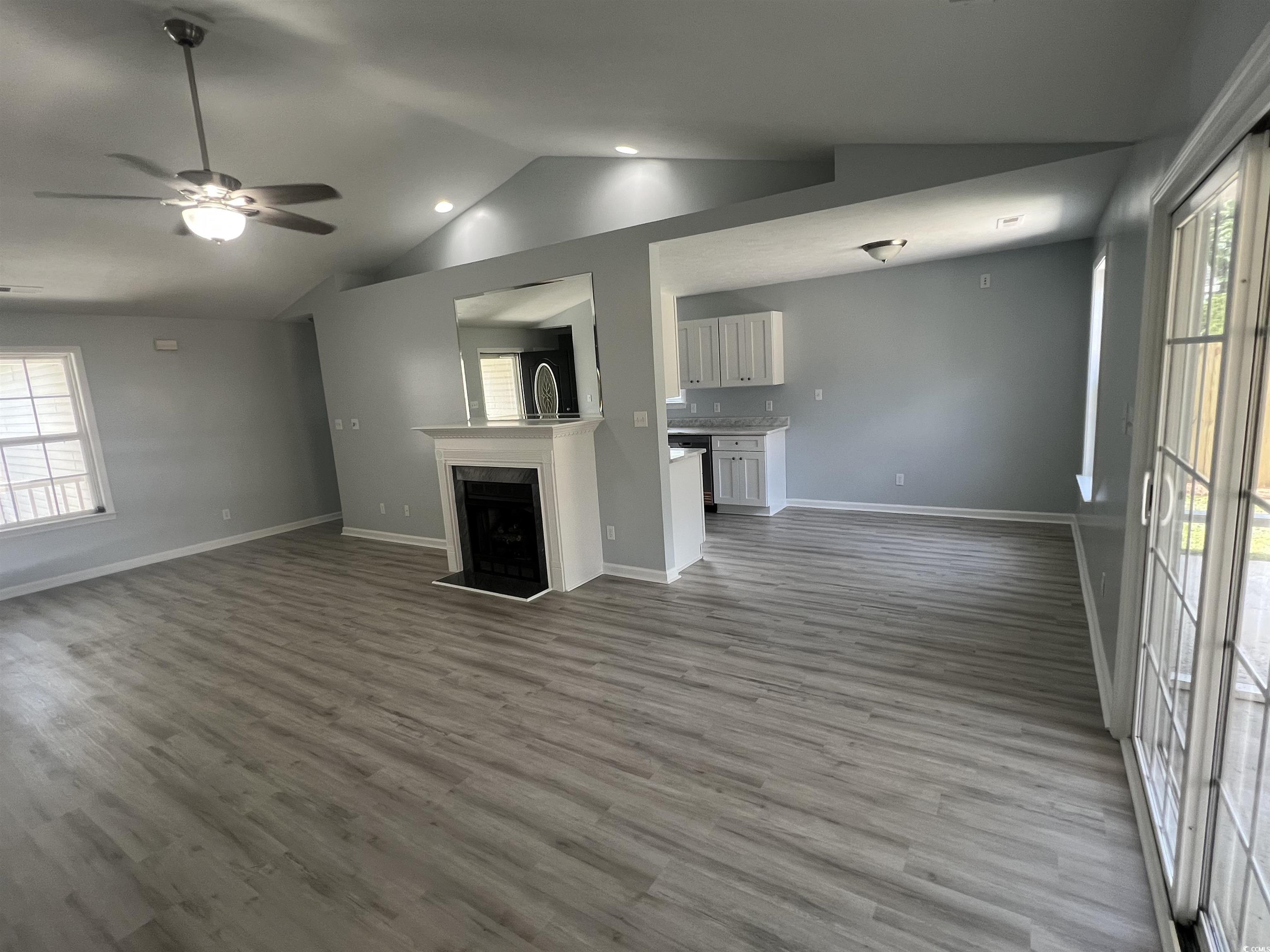 9888 Conifer Lane Murrells Inlet, SC 29576 - Photo 4 of 11 Unfurnished living room with vaulted ceiling, wood