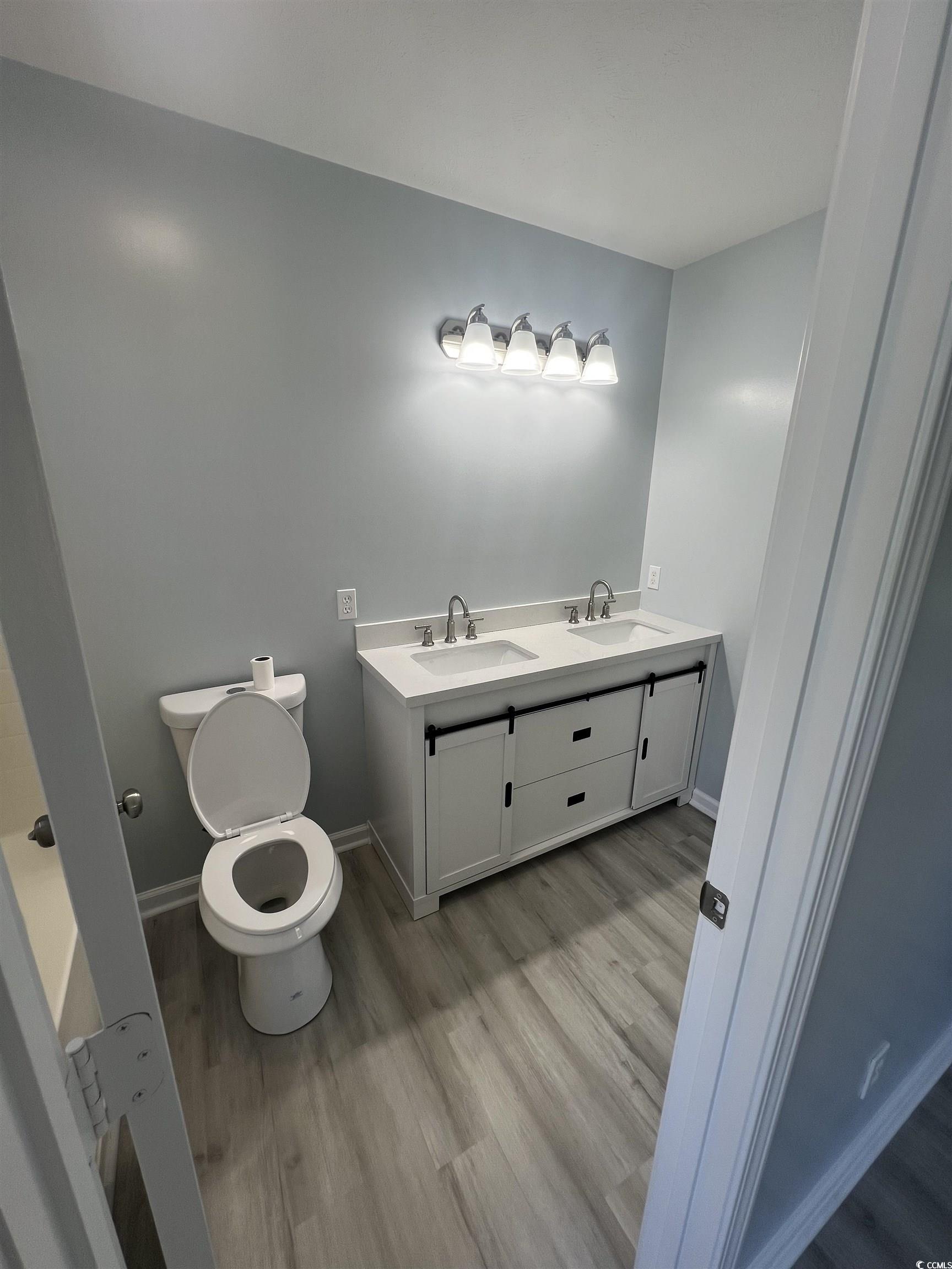 9888 Conifer Lane Murrells Inlet, SC 29576 - Photo 7 of 11 Bathroom featuring wood finished floors and double