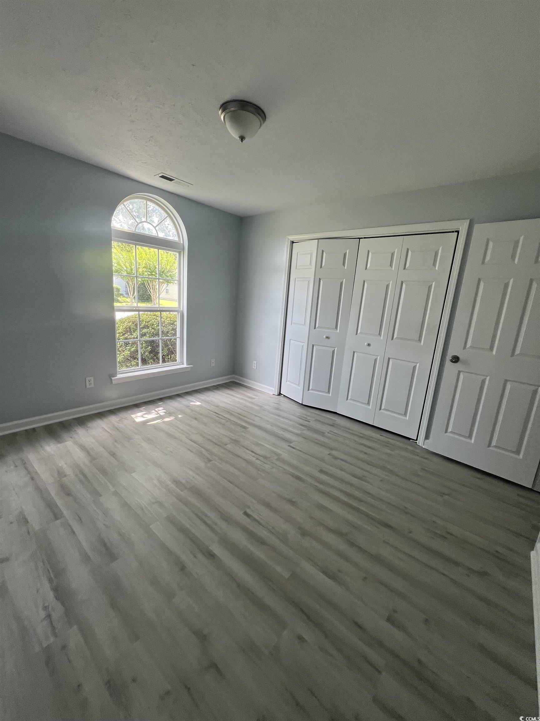 9888 Conifer Lane Murrells Inlet, SC 29576 - Photo 8 of 11 Unfurnished bedroom featuring wood finished floors