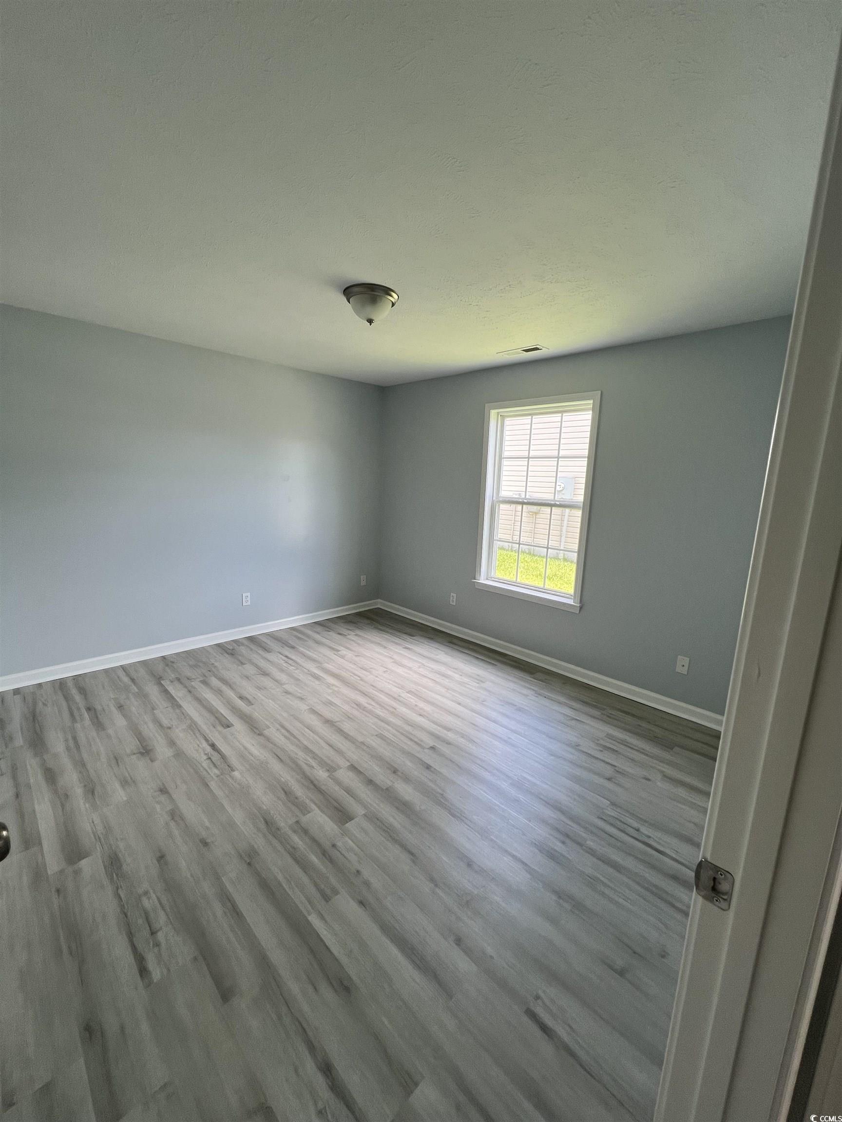 9888 Conifer Lane Murrells Inlet, SC 29576 - Photo 10 of 11 Unfurnished room with wood finished floors and bas