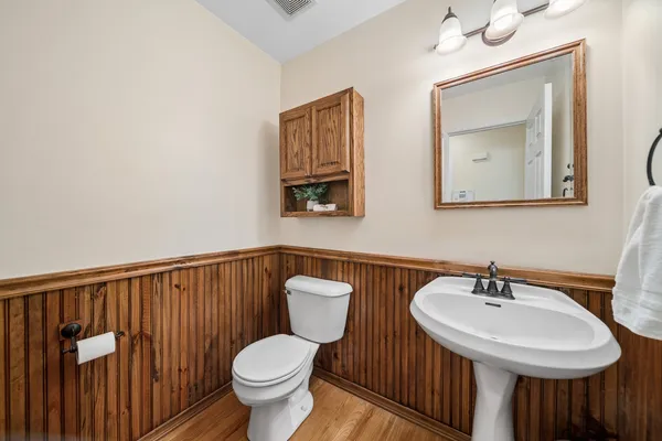 a bathroom with a toilet a sink and mirror