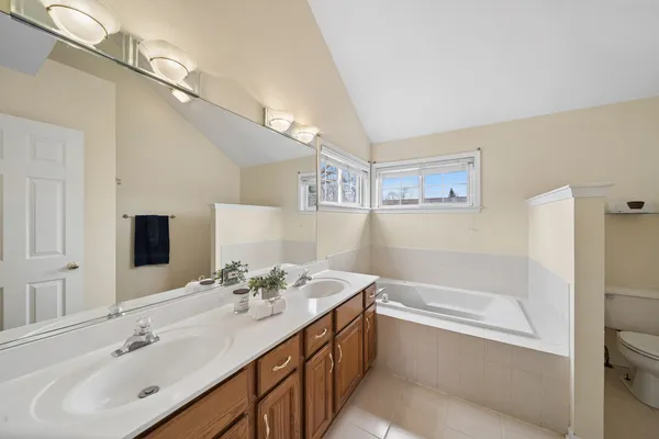 a bathroom with a tub sink and mirror
