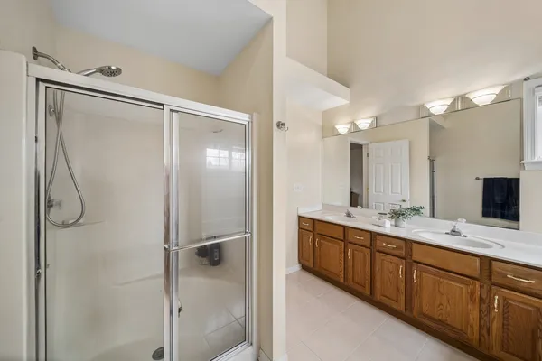 a bathroom with a double vanity sink mirror and shower