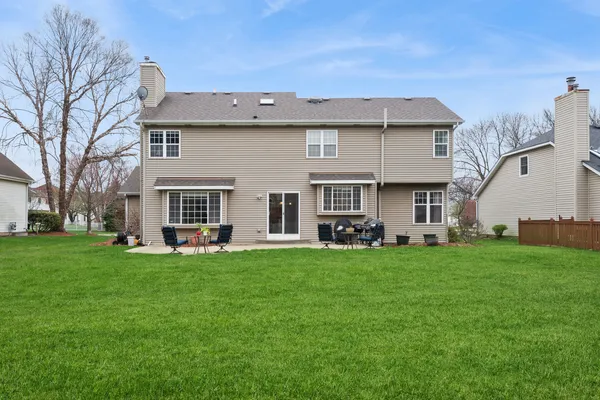 a view of a house with a yard and sitting area