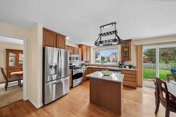 a kitchen with stainless steel appliances granite countertop a stove refrigerator and a view of living room