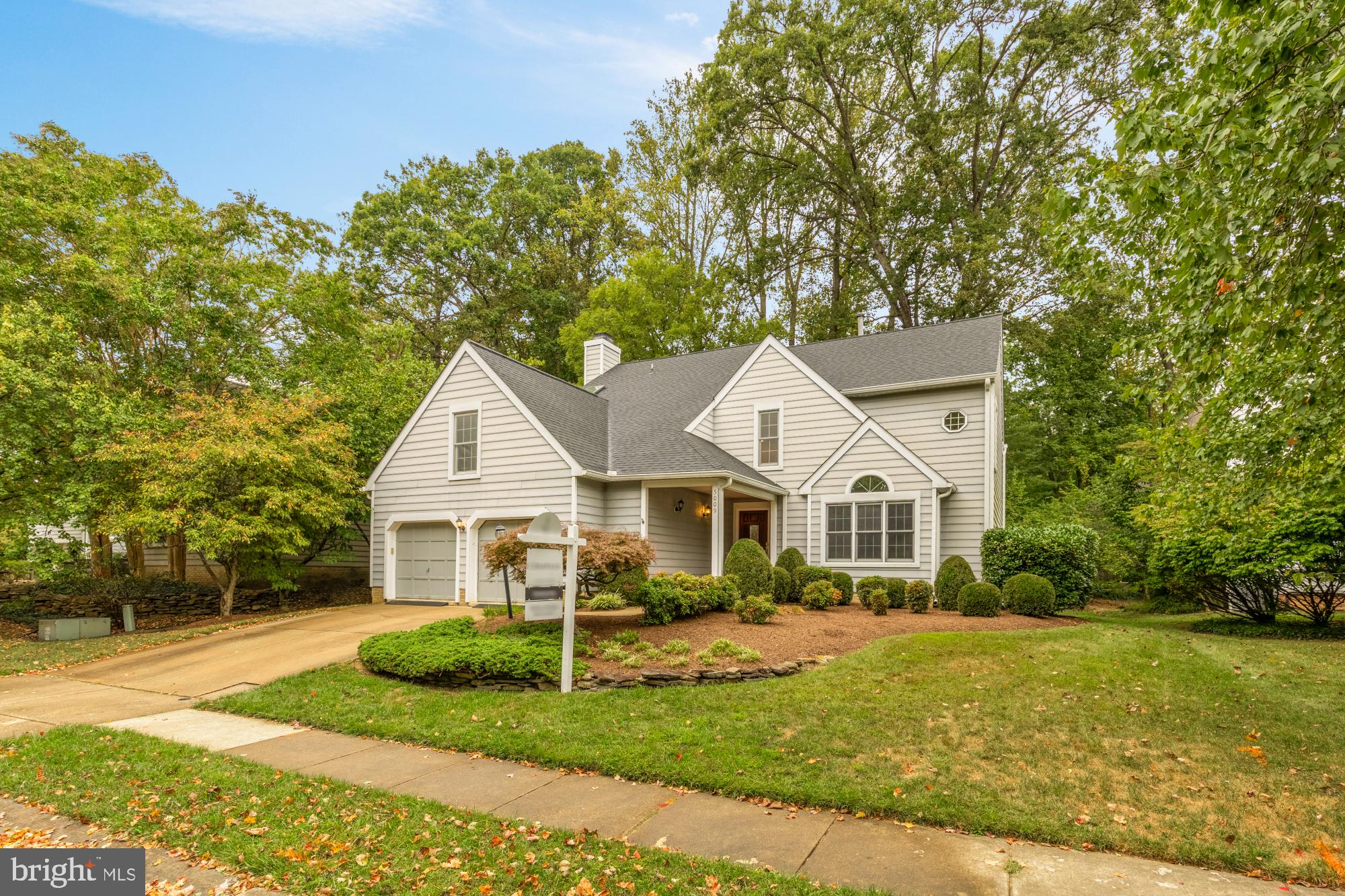 a view of a house with a big yard plants and large trees
