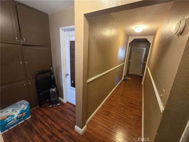 a view of a hallway with wooden floor and stairs